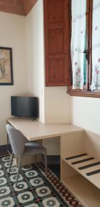 einen Schreibtisch mit einem Monitor und einem Stuhl in einem Zimmer in der Unterkunft Villa Bruna in Poggibonsi