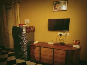 uma sala de estar com uma televisão e uma mesa e um tvictericter em OH Kolkata - Sutanuti Homestay em Calcutá