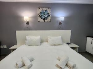 a bedroom with a large white bed with two pillows at Hippo Lodge Apartments in St Lucia