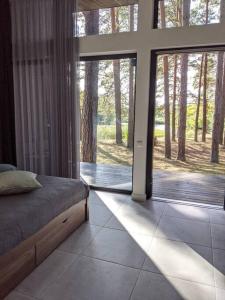 a bedroom with a bed and a large sliding glass door at GaujaUpe 2 in Gauja