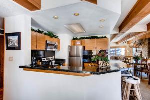 a kitchen with white walls and wooden cabinets at 2 Br 2Ba Spacious Condo With A Fireplace Condo in Crested Butte