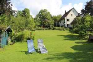 two chairs sitting in the yard of a house at Gästehaus Stöhr - Ihre Ferienwohnungen mit großem Garten und direktem Seezugang in Öhningen