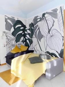 1 dormitorio con 1 cama con un mural de flores en la pared en Mediolanum Forum-Milano Sud Area-Free Parking & Wi-Fi en Buccinasco