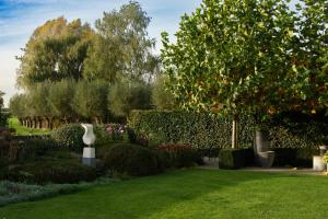 un jardín con césped verde, arbustos y árboles en B&B Bergdal, en Gits