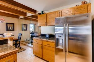 a kitchen with a stainless steel refrigerator and wooden cabinets at 2 Br With Open Floor Plan & Updated Kitchen Condo in Crested Butte