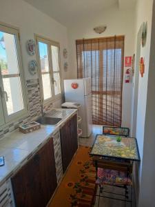 una cucina con lavandino e frigorifero di Sicilia Room a Carrozziere