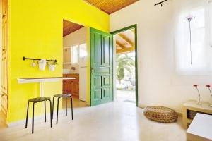a kitchen with yellow walls and a green door at Handmade house in Acharavi