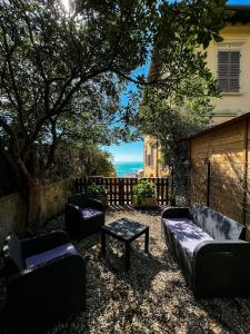 un patio con divani, tavolo e vista sull'oceano di Villino La Fresia a Castiglioncello