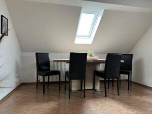 ein Esszimmer mit einem Tisch und 4 Stühlen in der Unterkunft Ferienwohnung Berghaus in Warendorf