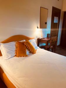 a bedroom with a bed with two pillows and a desk at Hotel More di Cuna in Monteroni dʼArbia