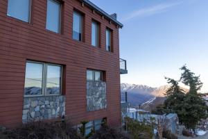 a red house with mountains in the background at Casa Farellones in Farellones