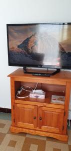 een flatscreen-tv op een houten standaard bij 2 pièces calme et fonctionnel in Cagnes-sur-Mer