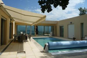 a swimming pool with a table and chairs next to a house at La Beaume in Blauvac
