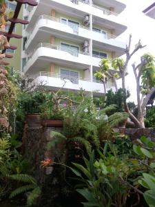 een appartementencomplex met planten ervoor bij Daisy Residence in Jomtien Beach
