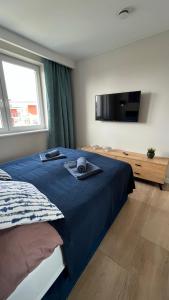 1 dormitorio con 1 cama y TV de pantalla plana en Resort Apartamenty Klifowa Rewal 55 en Rewal