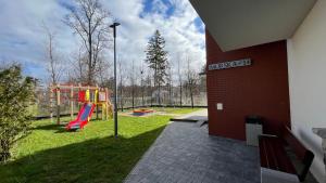 einen Park mit Spielplatz mit Rutsche in der Unterkunft Resort Apartamenty Klifowa Rewal 55 in Rewal