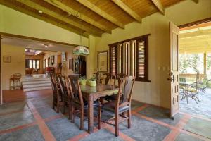 - une salle à manger avec une table et des chaises en bois dans l'établissement Fantastic Harmony Chalet in Pinar del Sol, à Jarabacoa