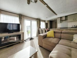 ein Wohnzimmer mit einem Sofa und einem Flachbild-TV in der Unterkunft Nightingale in South Cerney