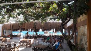 a restaurant with tables and chairs and a view of the ocean at Kervan Tatil Köyü in Edremit