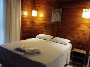 Schlafzimmer mit einem Bett mit Holzwänden und Holzböden in der Unterkunft VIA SPE - Pousada in Belo Horizonte