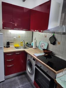 een keuken met rode kasten en een wasmachine bij Super Stylish Studio II in Thessaloniki