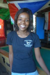 a woman in a blue shirt standing in front of a slide at Eagles Nest hostel plus self catering private units in Coffee Bay