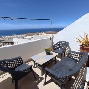une terrasse avec des chaises et une table et l'océan dans l'établissement Aguas Verdes, à Betancuria