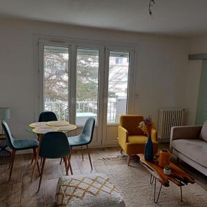 ein Wohnzimmer mit einem Sofa, einem Tisch und Stühlen in der Unterkunft Beau T3 60m2 très cosy proche du centre ville in Saint-Jacques