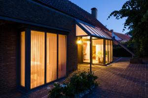 a house with large windows on the side of it at Wellnessvakantiehuis Victorello in Heuvelland