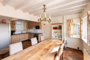une salle à manger avec une table en bois et un lustre dans l'établissement Wellnessvakantiehuis Victorello, à Heuvelland