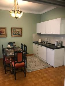 a kitchen with white cabinets and a table and a dining room at Sweet Home Serres premium living in Serres