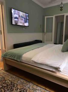 a bedroom with a bed with a tv on the wall at Sweet Home Serres premium living in Serres