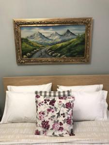 a painting above a bed with a pillow on it at Sweet Home Serres premium living in Serres