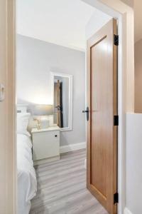 a bedroom with a bed and a wooden door at Ardoyne Lodge 'Sleeping 4 Guests' in Belfast