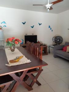 ein Wohnzimmer mit einem Esstisch mit Schmetterlingen an der Wand in der Unterkunft Casa de temporada Lar Doce Mar de Itauna in Saquarema