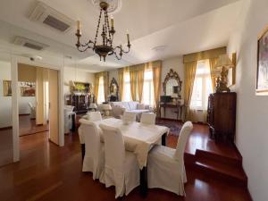 uma sala de jantar com uma mesa branca e cadeiras brancas em Trieste Luca's Home em Trieste