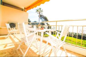 a white table and chairs on a balcony at Le Trident YourHostHelper in Cannes