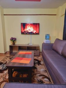 sala de estar con sofá y chimenea en 2 bedroom Airbnb TRM drive Roysambu, en Nairobi