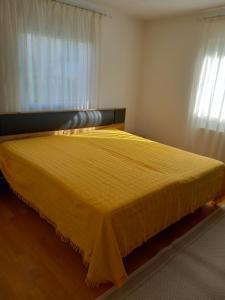 a yellow bed in a room with a window at Ferienhaus Carolin in Heidenheim
