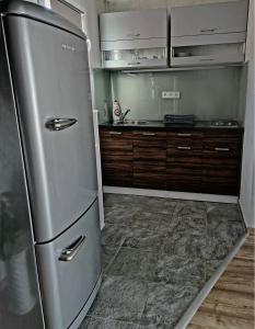 La cuisine est équipée d'un réfrigérateur en acier inoxydable et de placards en bois. dans l'établissement Villa Felícia, à Balatonszepezd