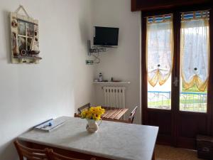 - une table à manger avec un vase de fleurs dans l'établissement Appartamenti Ancora Azzurra, à Deiva Marina