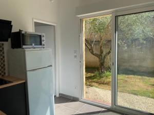 een keuken met een koelkast en een raam bij Gîte Lou Sabaï au pied des dentelles de Montmirail, piscine partagée in Aubignan