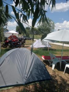 a tent and a motorcycle and a man on a motor bike at Camping Danubius Tulcea in Tulcea
