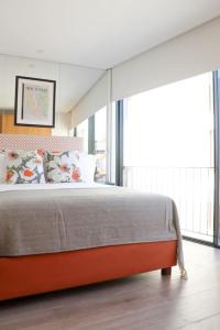 - une chambre avec un grand lit et une grande fenêtre dans l'établissement T'Luz, à Porto