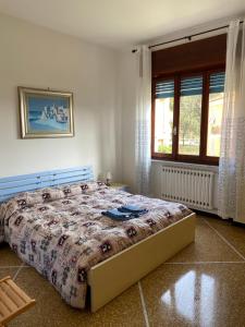 Un dormitorio con una cama en una habitación con ventana. en Appartamenti Ancora Azzurra, en Deiva Marina