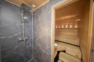 a bathroom with a sauna with a shower at Tunturihuoneisto LAAKEUS in Syöte