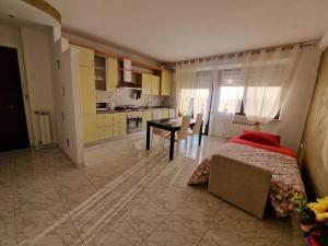 ein Schlafzimmer mit einem Bett und einem Tisch sowie eine Küche in der Unterkunft Appartamento Divino Tramonto in Altedo