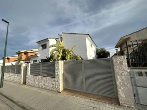 uma cerca em frente a uma casa branca em Villa with private Pool & Garden em Riba-roja de Túria