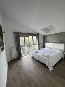 um quarto com uma cama grande e uma janela grande em Villa with private Pool & Garden em Riba-roja de Túria