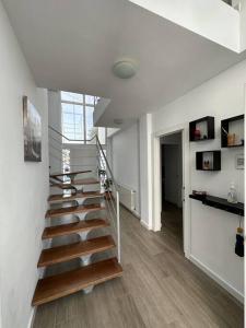 eine Treppe in einem Zimmer mit weißen Wänden und Holzböden in der Unterkunft Villa with private Pool & Garden in Riba-roja de Túria